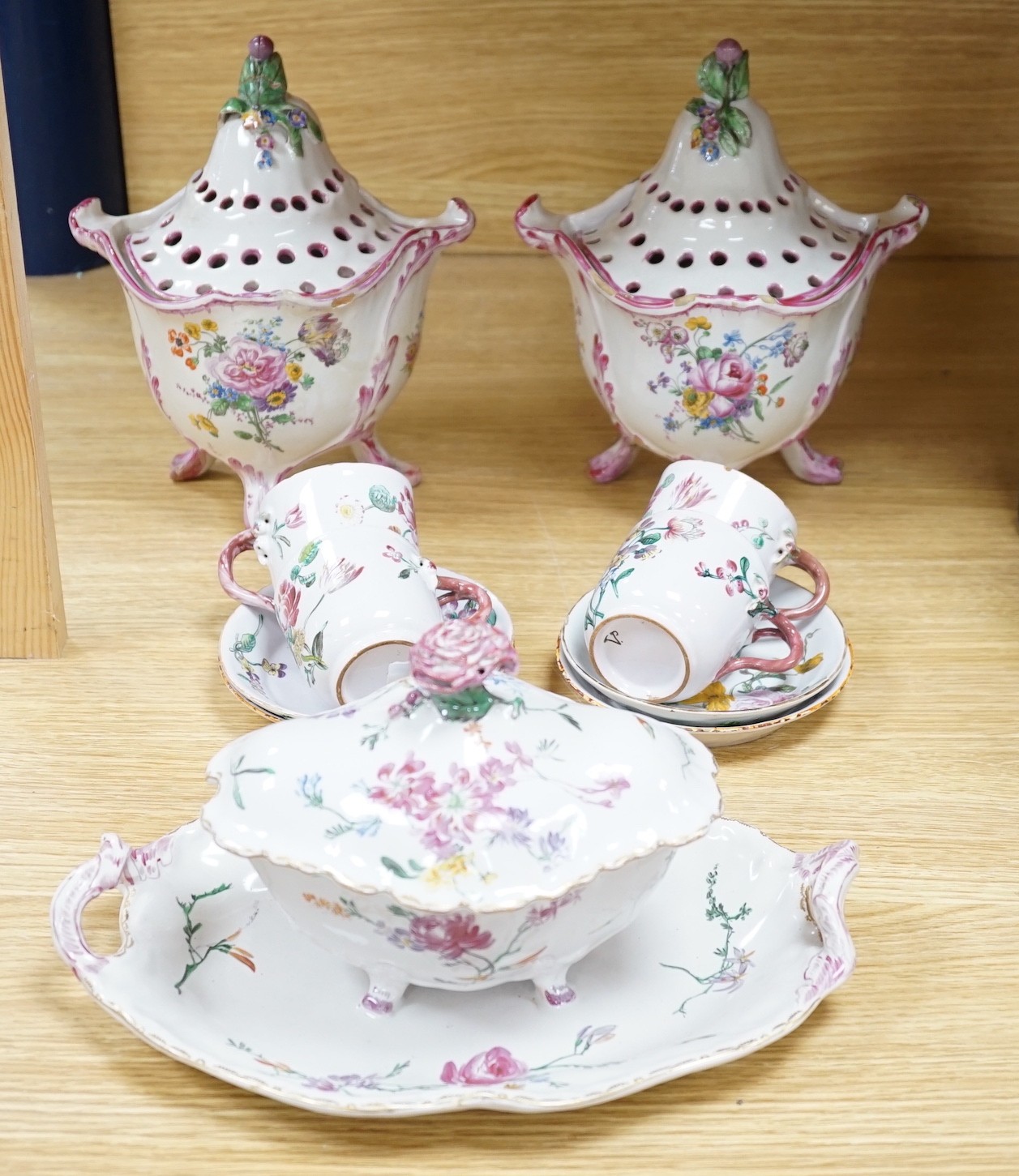 A group of of French faience pottery including a pair of pot pourri vases and covers, a tureen with integral stand, cover, ladle and four coffee cups and saucers